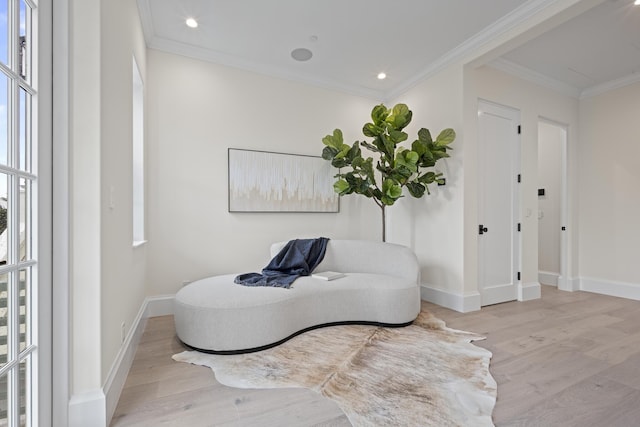 sitting room with light hardwood / wood-style floors and crown molding