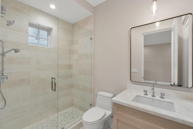 bathroom with an enclosed shower, vanity, and toilet