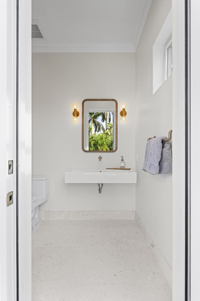 bathroom featuring toilet and ornamental molding