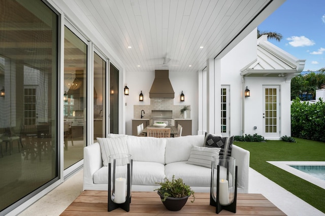 interior space with area for grilling, a lawn, a patio area, and exterior kitchen