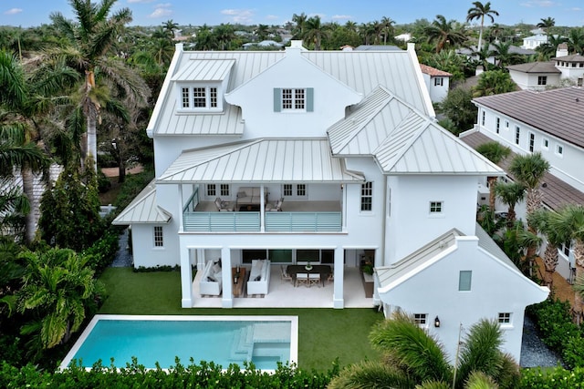 rear view of house featuring a yard, a patio area, and a balcony