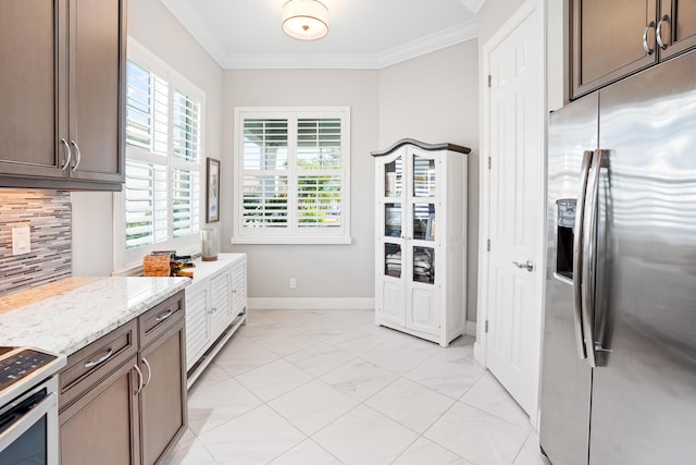 kitchen featuring crown molding, dark brown cabinetry, and stainless steel appliances