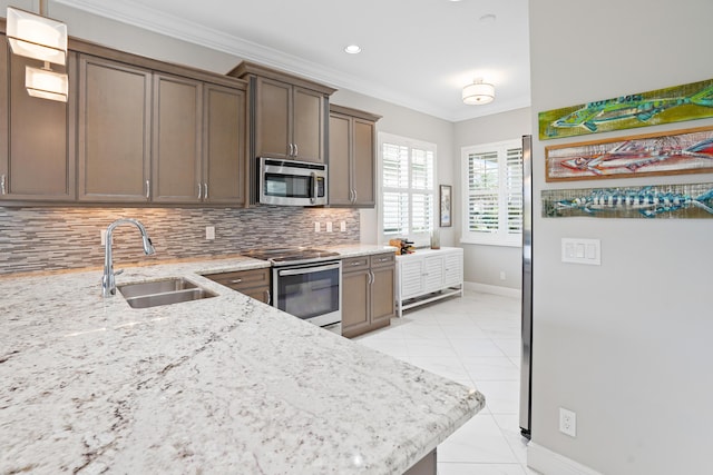 kitchen with backsplash, crown molding, sink, appliances with stainless steel finishes, and light stone counters