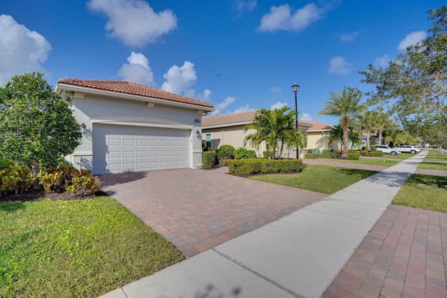 mediterranean / spanish house featuring a front yard and a garage