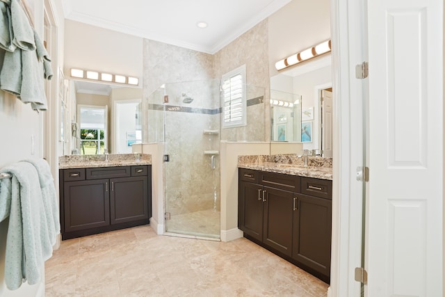 bathroom featuring ornamental molding, vanity, a shower with door, and a healthy amount of sunlight