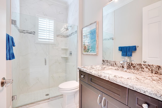 bathroom with vanity, toilet, ornamental molding, and a shower with door