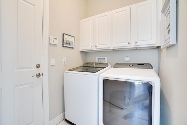 washroom featuring cabinets and separate washer and dryer