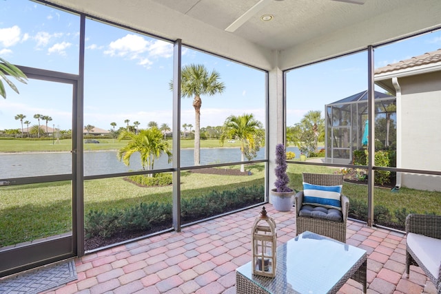 unfurnished sunroom with ceiling fan and a water view