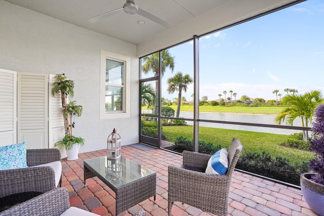 sunroom with a water view, a wealth of natural light, and ceiling fan