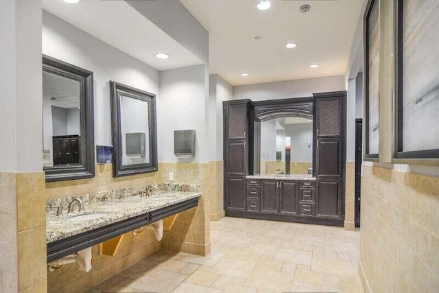 bathroom featuring vanity and tile walls