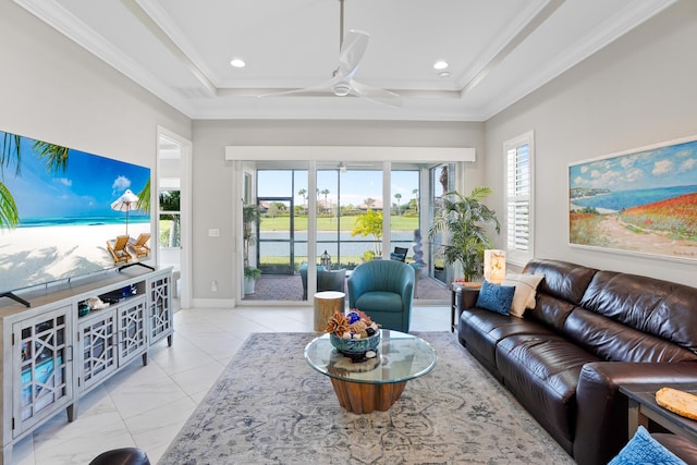 living room featuring ceiling fan, a raised ceiling, and ornamental molding