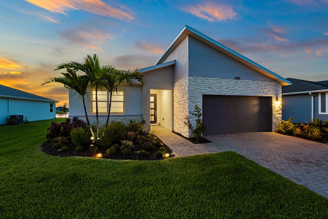 view of front of house with a garage and a lawn