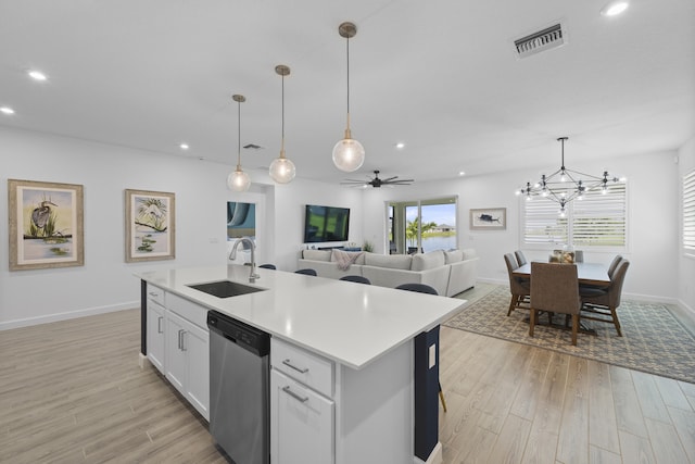 kitchen with white cabinetry, dishwasher, sink, and a center island with sink