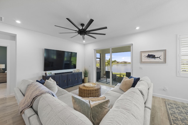 living room with light hardwood / wood-style flooring and ceiling fan