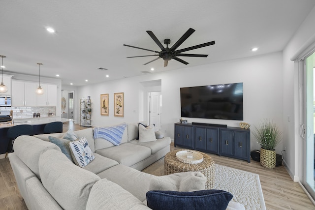 living room featuring ceiling fan and light wood-type flooring