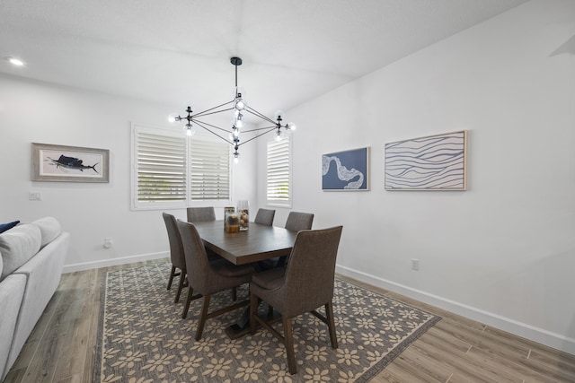 dining room with hardwood / wood-style floors and a notable chandelier