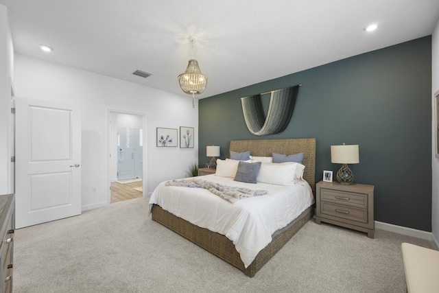 carpeted bedroom featuring connected bathroom and a chandelier