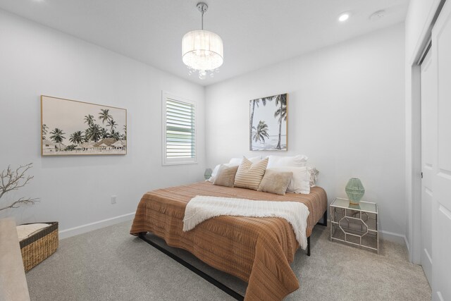 bedroom with light carpet, a notable chandelier, and a closet