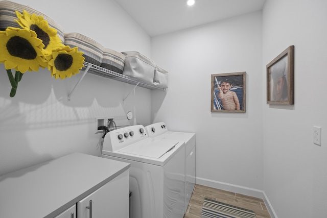 clothes washing area featuring washer and clothes dryer and cabinets