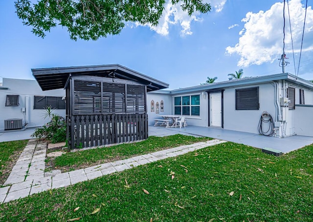 rear view of house with a yard, cooling unit, and a patio area