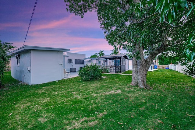 yard at dusk featuring a patio and central AC unit