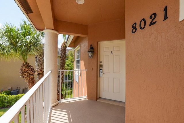 property entrance with cooling unit and a balcony