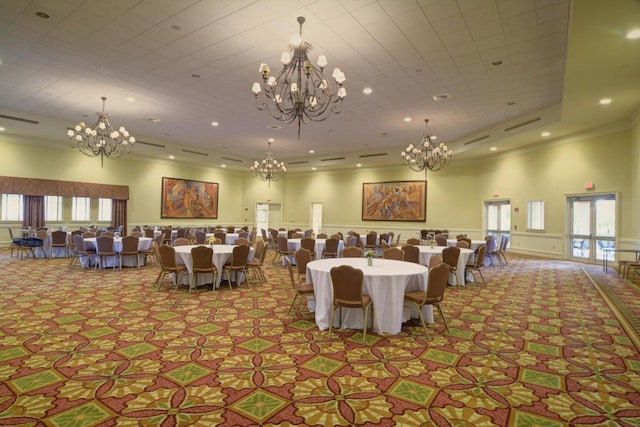 dining space with french doors, a towering ceiling, a raised ceiling, and ornamental molding