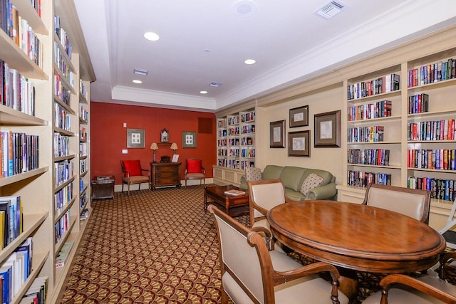 sitting room featuring carpet flooring, built in features, a raised ceiling, and ornamental molding