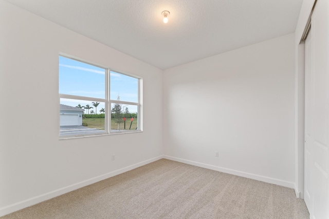 empty room with baseboards and light carpet