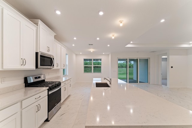 kitchen featuring white cabinetry, sink, light stone counters, and stainless steel appliances