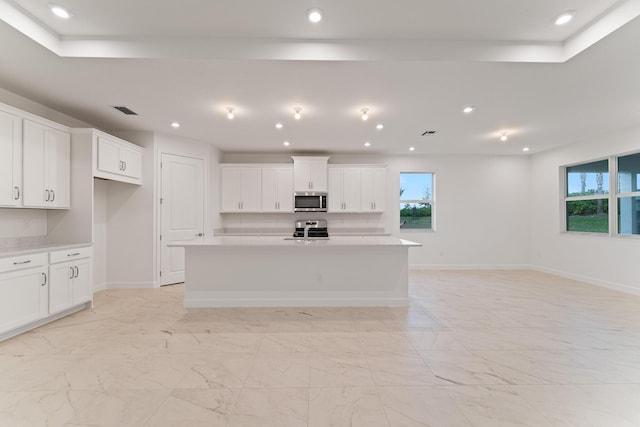 kitchen featuring an island with sink, appliances with stainless steel finishes, and white cabinets