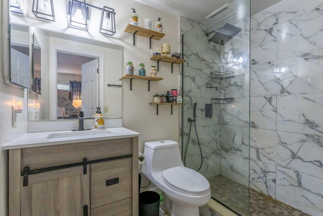 bathroom featuring a tile shower, vanity, and toilet