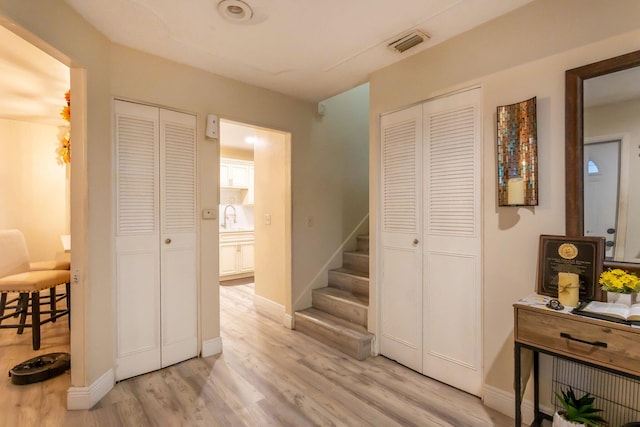 hallway with light hardwood / wood-style floors and sink