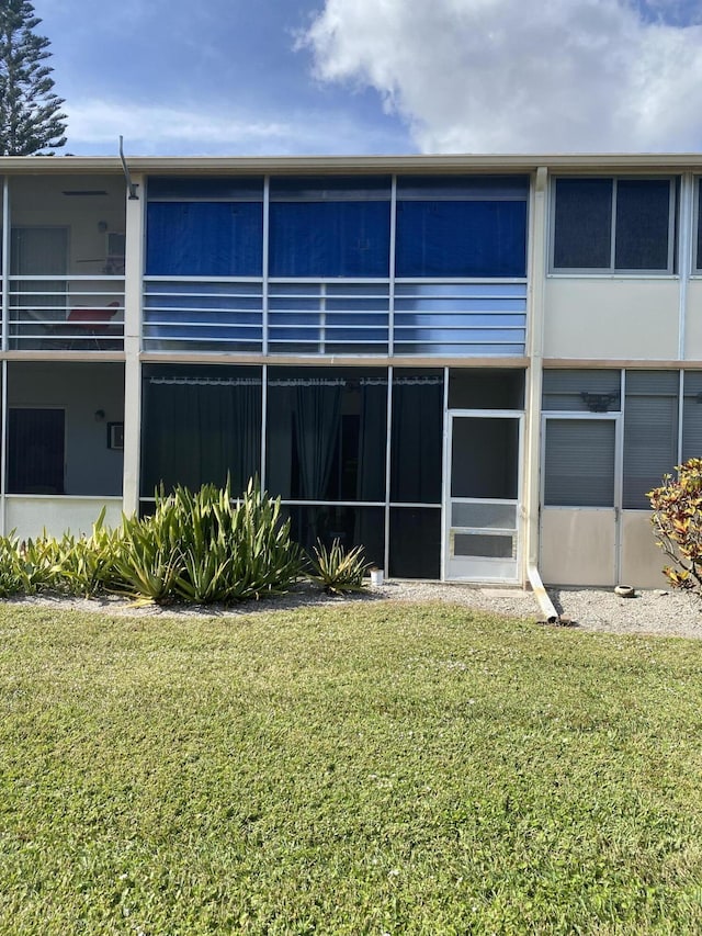 rear view of property featuring a yard