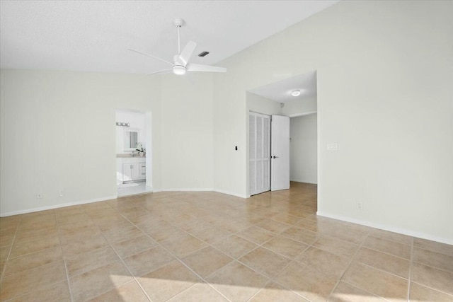 unfurnished room with light tile patterned floors, vaulted ceiling, and ceiling fan