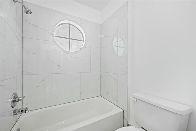 bathroom featuring toilet and tiled shower / bath