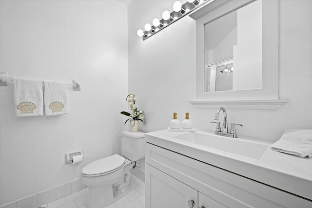 bathroom featuring toilet, vanity, tile patterned floors, and a shower with door