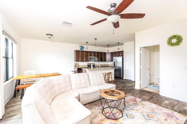 living room featuring ceiling fan and dark hardwood / wood-style flooring