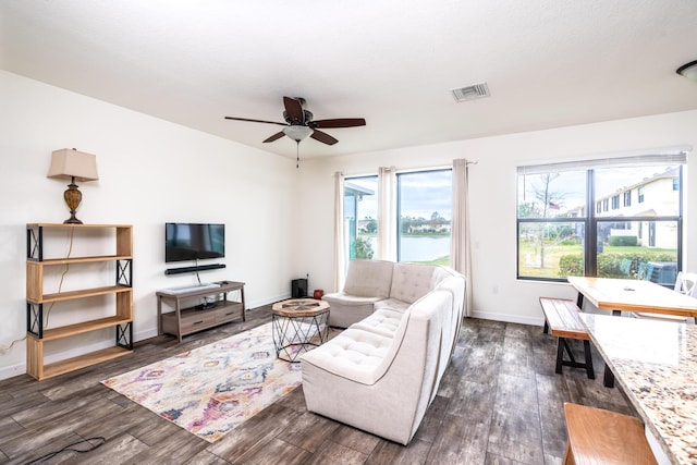 living room featuring ceiling fan, a healthy amount of sunlight, and dark hardwood / wood-style flooring