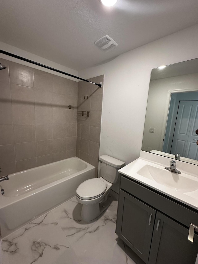 full bathroom with a textured ceiling, vanity, tiled shower / bath combo, and toilet