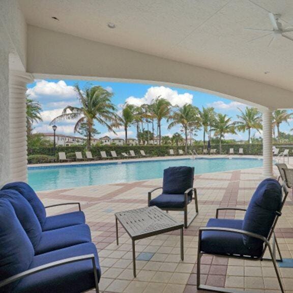 view of swimming pool with ceiling fan and a patio