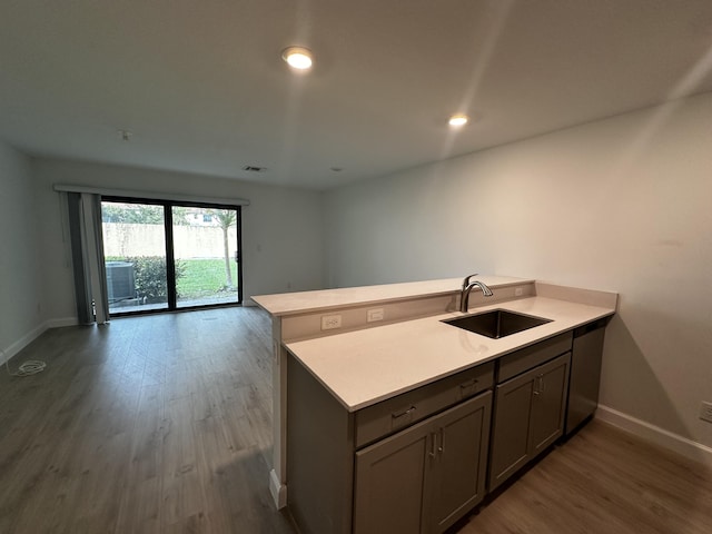 kitchen featuring kitchen peninsula, hardwood / wood-style floors, and sink