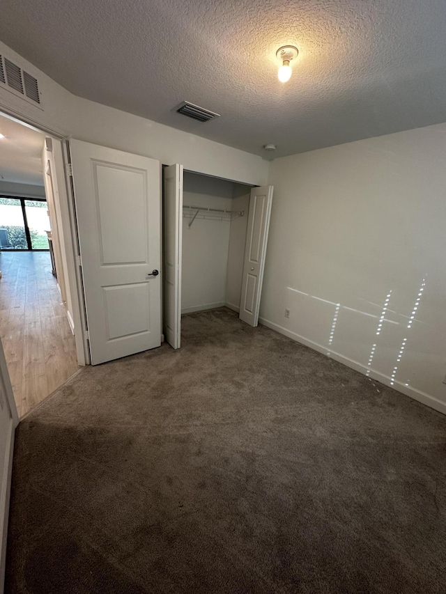 unfurnished bedroom featuring wood-type flooring and a textured ceiling