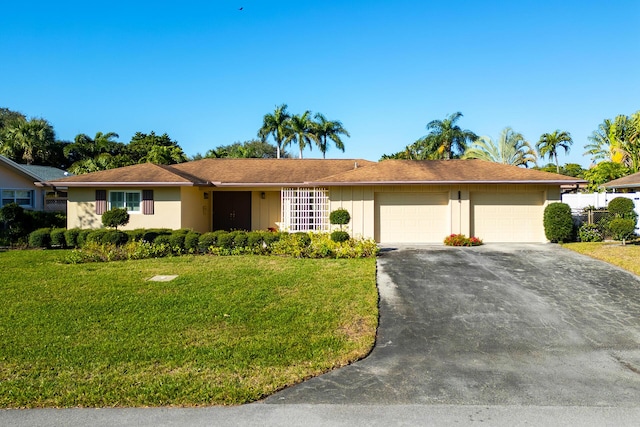 single story home featuring a garage and a front yard