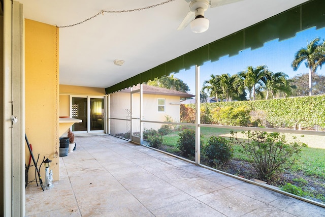 unfurnished sunroom with ceiling fan