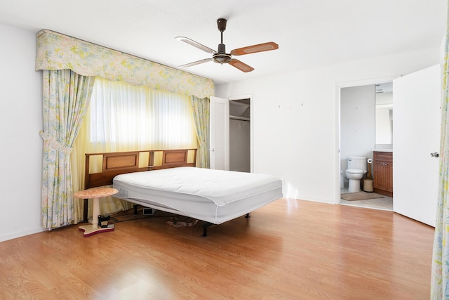 bedroom featuring ensuite bath, ceiling fan, light hardwood / wood-style floors, a walk in closet, and a closet