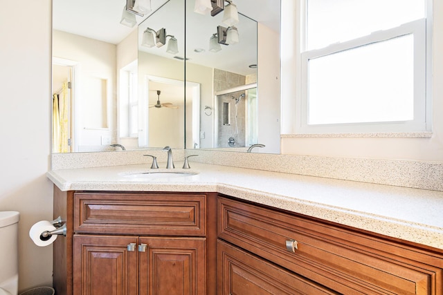 bathroom with vanity, toilet, and a shower with door