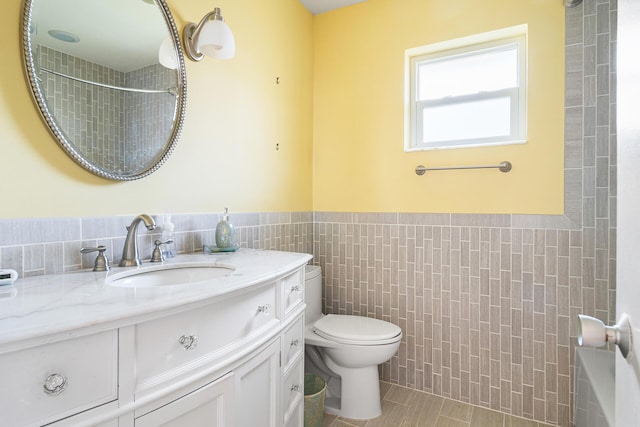 bathroom featuring tile walls, vanity, tile patterned floors, and toilet