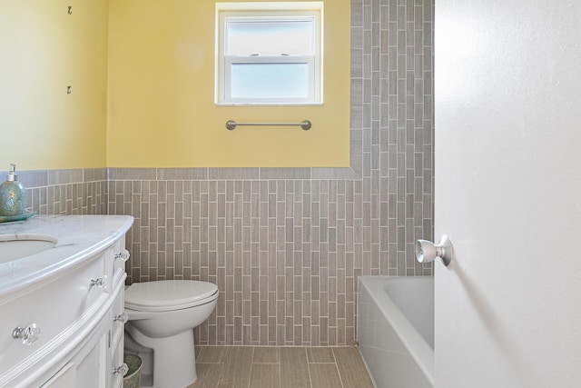 full bathroom featuring shower / bathtub combination, vanity, toilet, and tile walls