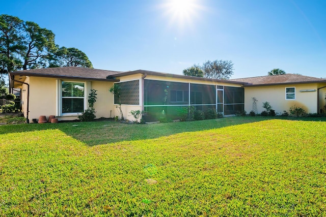 back of property featuring a yard and a sunroom